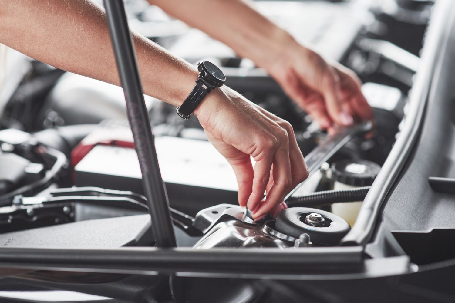 person checking car engine